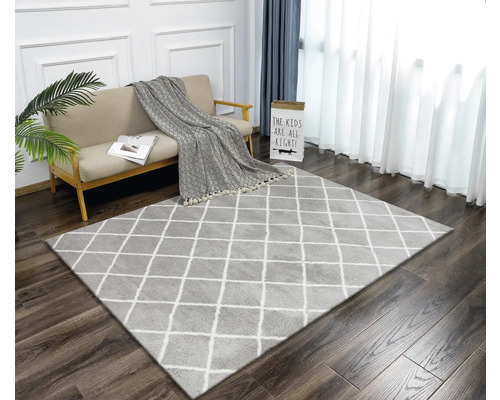 Cameră de zi cu covor cu model în romburi, canapea și perdele