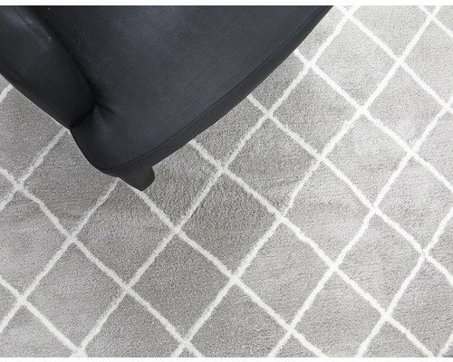 Covor cu model în romburi lângă un fotoliu