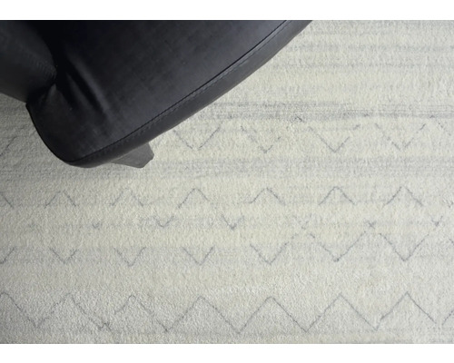 Prim-plan cu un covor cu model geometric și picior de scaun
