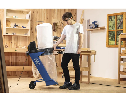 Sistem de extracție a prafului Scheppach utilizat într-un atelier cu un bărbat.