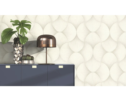 Tapetă decorativă cu model circular în spatele unei comode cu lampă și plante