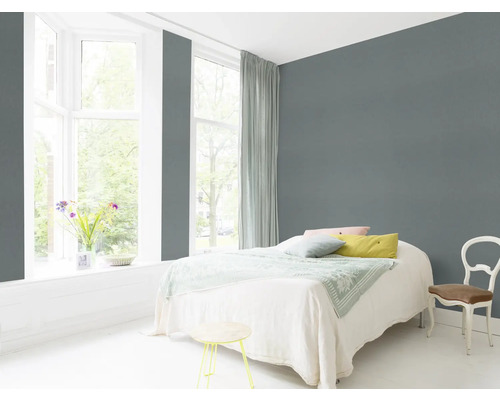 Dormitor luminos cu pat, scaun și perete gri