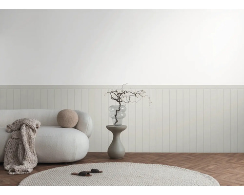 Interior luminos cu canapea, măsuță laterală și elemente decorative în fața lambriului.