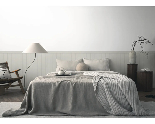 Dormitor luminos cu pat, noptiere, lampadar și fotoliu