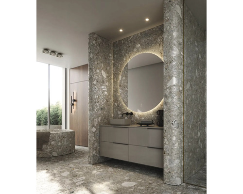 Baie modernă cu gresie tip terrazzo, oglindă rotundă cu iluminare și dulap de bază pentru lavoar