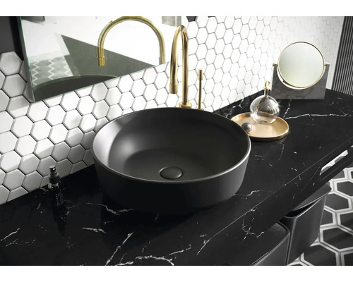 Chiuvetă pe blat în baie cu robinet, oglindă și faianță hexagonală