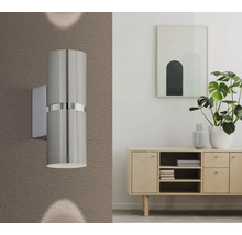 Aspect interior modern cu o lampă de perete metalică lângă un bufet