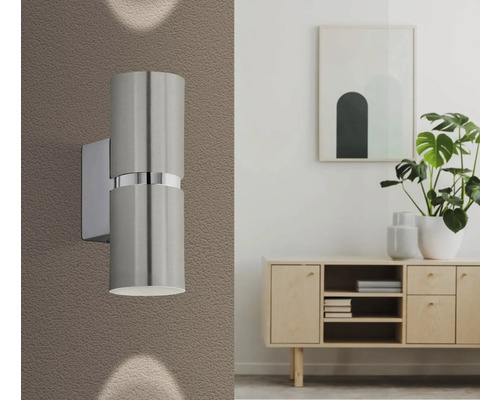 Aspect interior modern cu o lampă de perete metalică lângă un bufet