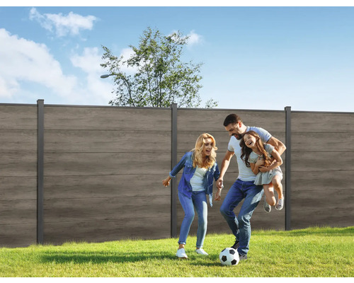 Familie joacă fotbal în grădină cu gard de intimitate