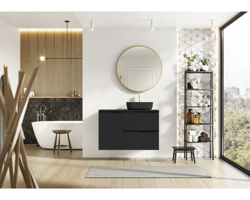 Baie modernă cu lavoar negru, oglindă, cadă și raft.