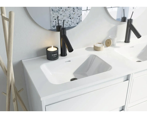 Chiuvetă de baie modernă cu robinet, oglindă și decorațiuni.