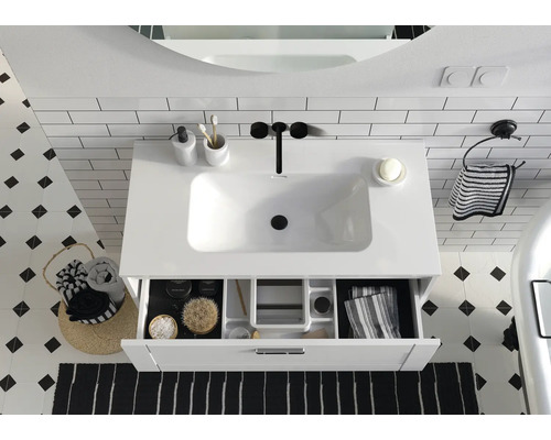 Chiuvetă de baie cu element de sertar deschis, completată de accesorii pentru un decor elegant.