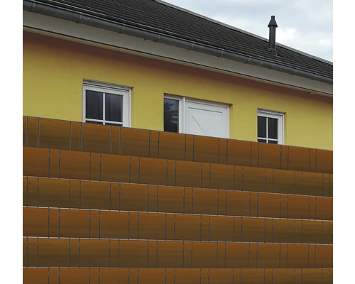 Gard de protecție a intimității în fața unei case galbene