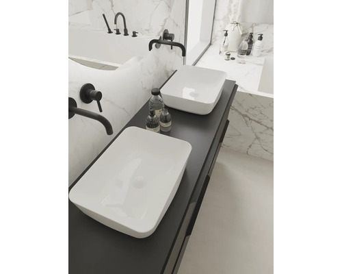 Baie luminoasă cu două lavoare așezate pe o placă de lavoar închisă la culoare și armături