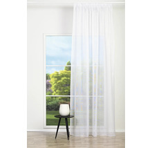 Cortină albă atârnând în fața unei ferestre într-o cameră luminoasă.