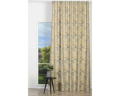 Cortină decorativă cu model de frunze în fața unei ferestre