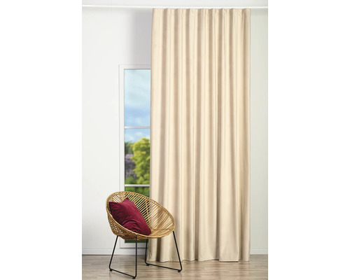 Perdea bej lângă o fereastră și un scaun de ratan cu o pernă
