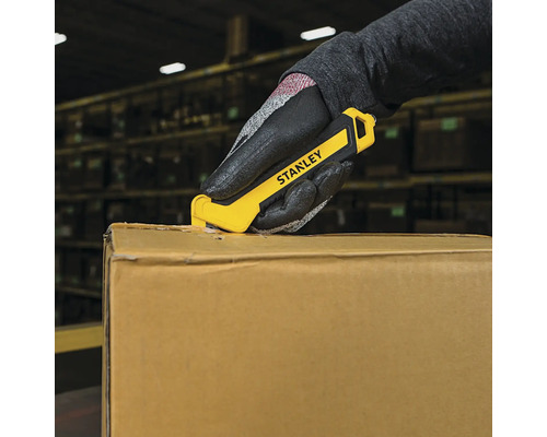 Mână cu mănușă deschizând un carton cu un tăietor de cuțit Stanley