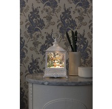 Felinar decorativ cu motiv de Crăciun pe o comodă