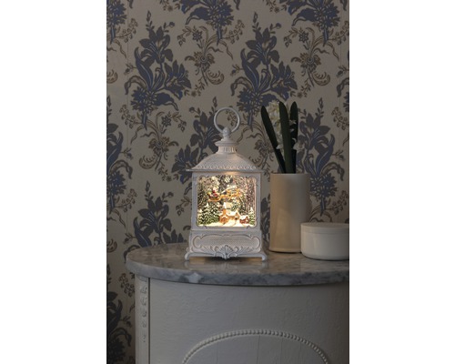 Felinar decorativ cu motiv de Crăciun pe o comodă