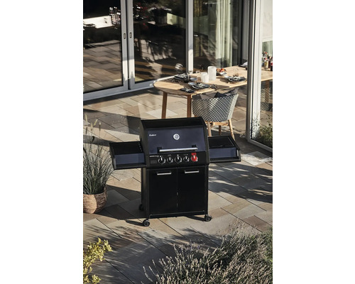 Grătar pe gaz cu mese laterale pe o terasă cu masă și scaune