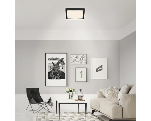 Cameră de zi cu plafonieră pătrată, canapea și tablouri decorative pe perete.