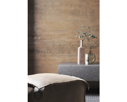 Vedere a unei încăperi cu un taburet, o măsuță laterală și obiecte decorative în fața unui perete cu model