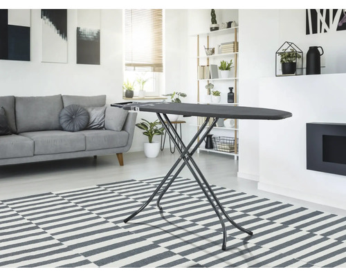 Masa de călcat într-un living luminos cu canapea și covor.