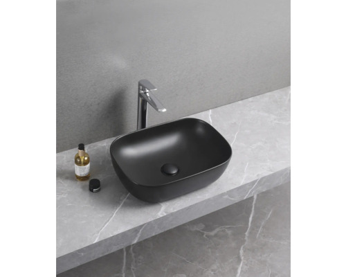 Chiuvetă neagră așezată cu robinet pe placă de marmură