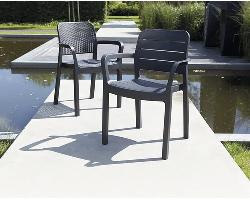 Două scaune de grădină gri din plastic cu brațe sunt așezate afară