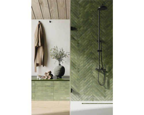 Baie cu gresie verde în model herringbone, duș și prosoape