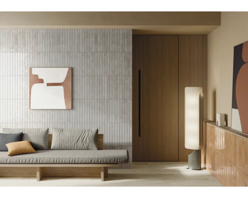 Living cu perete cu faianță, canapea și iluminat decorativ pentru o ambianță modernă.