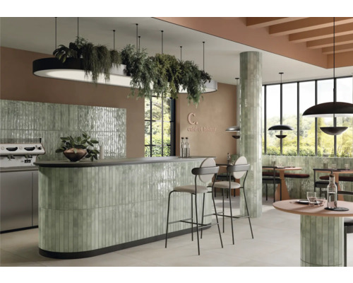 Fotografie de interior a unei cafenele cu placări cu gresie, scaune și iluminat