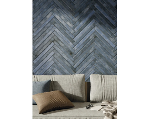 Decor de perete cu plăci ceramice în model herringbone deasupra canapelei