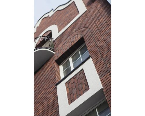 Fațadă de clădire cu zidărie din cărămidă, ferestre și balcon