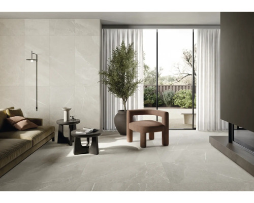 Living cu gresie și faianță cu aspect de marmură, canapea, fotolii și plantă de apartament.