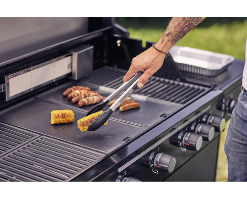 O persoană face grătar cu porumb și cârnați pe un grătar.