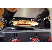 Pizza pe o piatră de pizza este împinsă într-un grătar pe gaz