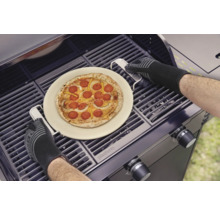 Pizza pe piatră pentru pizza este pregătită pe grătar cu mănuși de grătar.