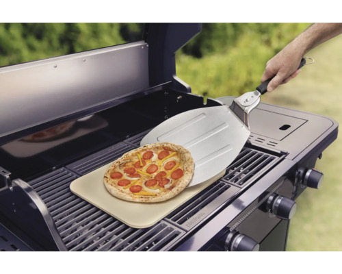 Pizza pe o piatră de pizza pe un grătar cu o paletă de pizza