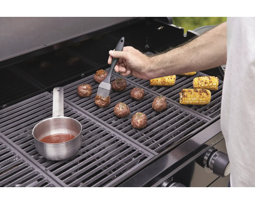 Chiftele și știuleți de porumb sunt preparate pe un grătar.