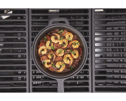 Tigaie din fontă cu creveți și cârnați pe un grătar