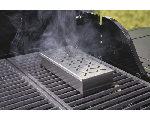 Cutie pentru afumat pe un grătar cu degajare de fum.