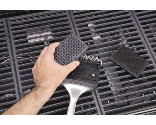 Persoană care curăță grătarul cu o perie de grătar