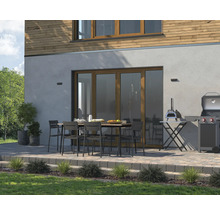 Terasa cu masă, scaune, grătar și cuptor de pizza în fața unei case