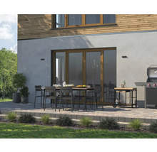 Terasa cu masă de sufragerie, scaune, grătar și cărucior pentru grătar în fața unei case