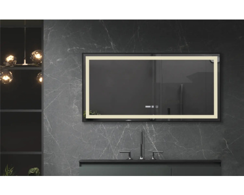 Oglindă iluminată cu ramă neagră deasupra unei chiuvete în baie