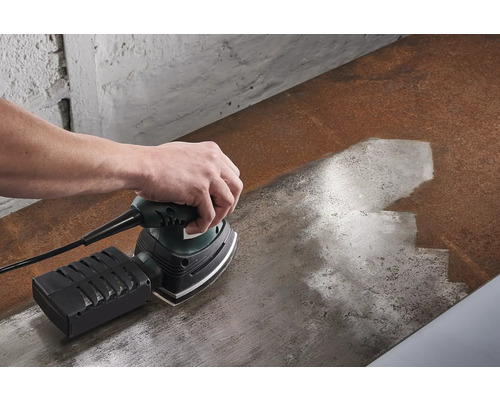 O persoană șlefuiește o suprafață de lemn cu o șlefuitoare vibratoare.