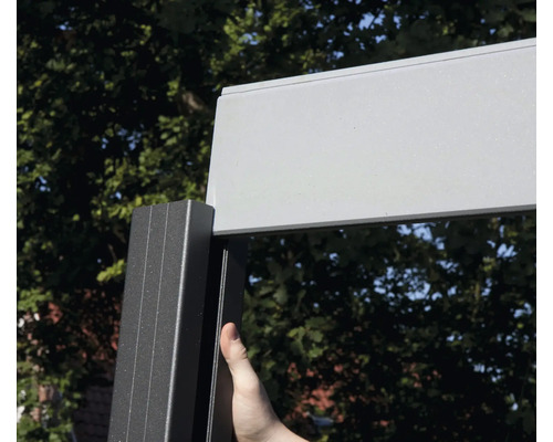 Detaliu al unui acoperiș de terasă cu cadru din aluminiu și o persoană care atinge cadrul.