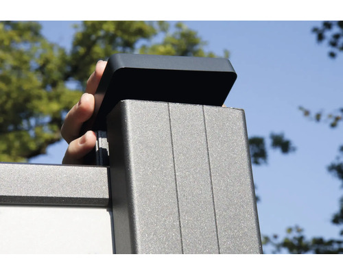 O mână așază un capac pe un stâlp de gard